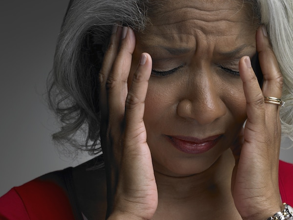 woman with head in hands and eyes closed, close-up