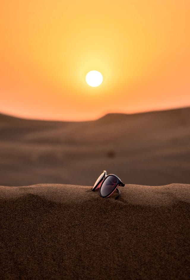 sun glasses on a sand dune in the desert