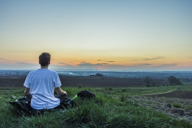 Person meditating on a hill