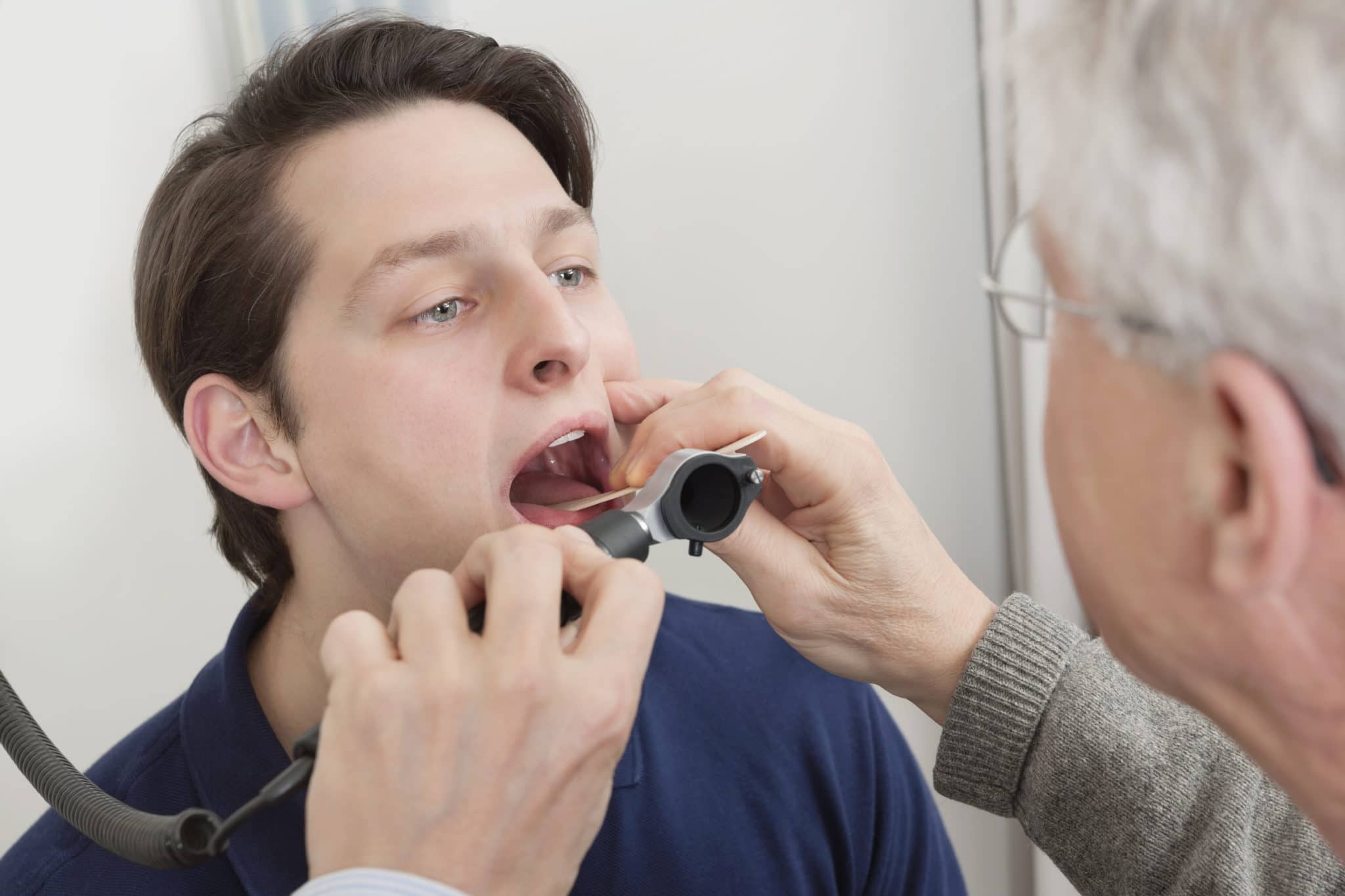 Doctor looking into patient's throat