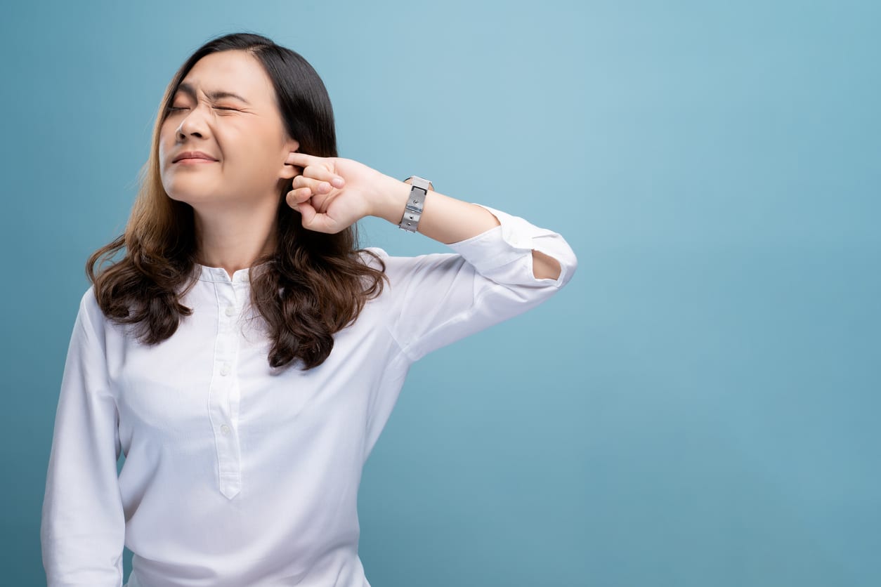 Woman putting a finger into her ear