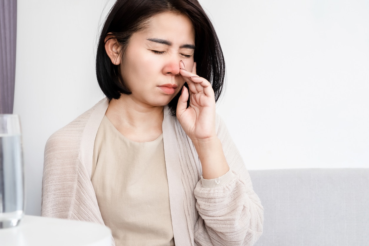 Woman holding her stuffed up nose