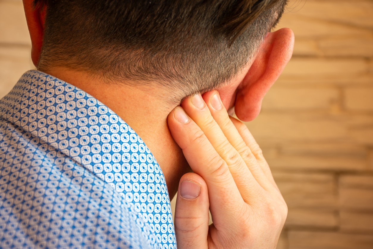 Man holds hand behind ear