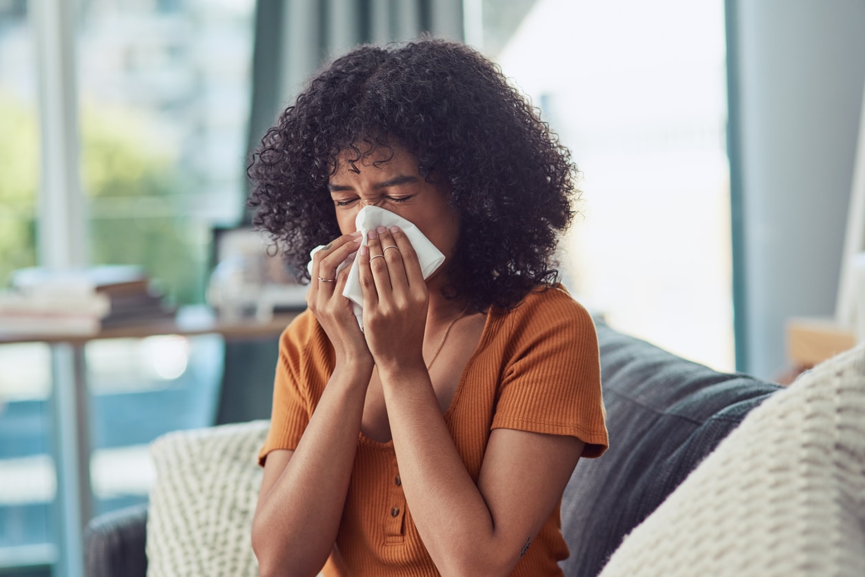 Young woman blowing her nose