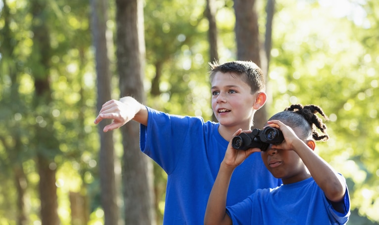 Kids at summer camp looking through binoculars