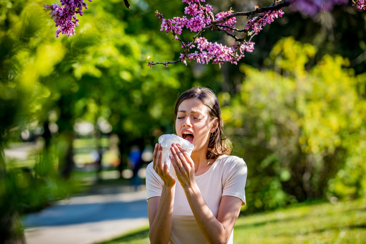 Woman sneezes in park